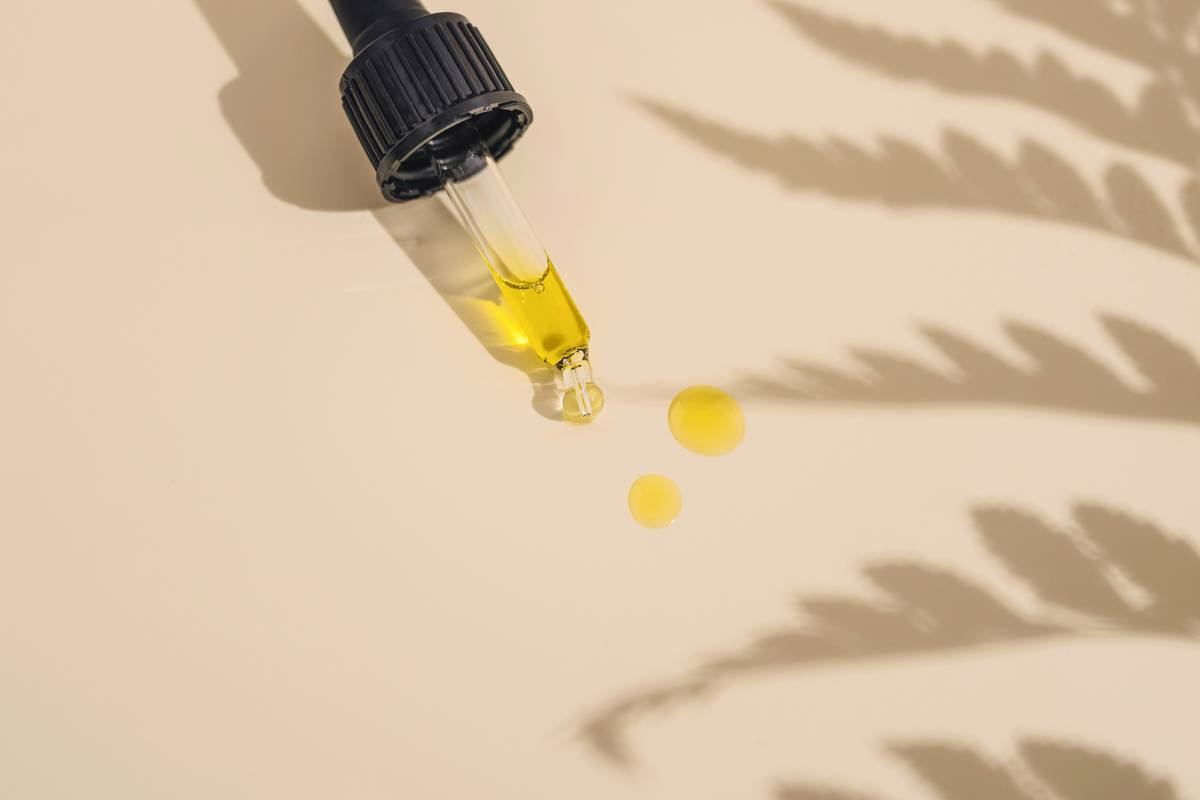 Close-up of fresh green leaves being distilled into cosmetics natural plant extract in a glass laboratory setup